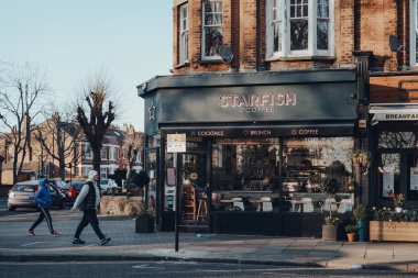 Londra, İngiltere - 22 Mart 2020: Palmers Green 'de kapalı bir Denizyıldızı Kafe, Londra Enfield İlçesi' nde bir banliyö bölgesi, yanından geçen insanlar, hareket bulanıklığı.