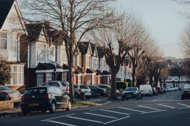 Londra, İngiltere - 22 Mart 2020: Londra 'nın kuzeyindeki Enfield İlçesi' nin bir banliyö bölgesi olan Palmers Green 'de bir caddedeki Edwardian evlerinin önüne park etmiş arabalar.