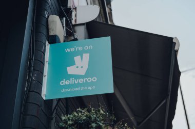 Londra, İngiltere - 12 Nisan 2020: Londra 'da bir restoranın önündeki Deliveroo tabelasındayız. Teslimat İngiliz doğumlu bir şirkettir. Yemeklerin teslimatı yapılmayan restoranlardan sağlanır..