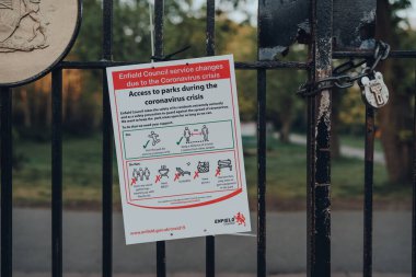 Londra, İngiltere - 12 Nisan 2020: Coronavirus tehdidi nedeniyle Londra 'nın Enfield kentindeki Broomfield parkının dışındaki çitlerdeki parklara erişimle ilgili uyarı ve rehberlik.