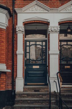 İngiltere, Londra 'da geleneksel bir Edwardian evinin leke kaplı ahşap kapısı, seçici odaklı..