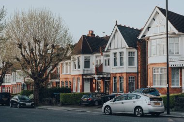 Londra, İngiltere - 12 Nisan 2020: Kuzey Londra 'daki Londra Enfield İlçesi' nde bir banliyö bölgesi olan Palmers Green 'de bir caddedeki Edwardian evlerinin önüne park edilmiş arabalar.