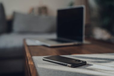 Londra, İngiltere - 5 Mayıs 2020: iPhone 11 Pro Max Apple 'ın evdeki bir masada, dizüstü bilgisayar arka planda, seçici odaklanma. Dünyanın dört bir yanındaki insanlar Coronavirüs yüzünden evden çalışıyor.