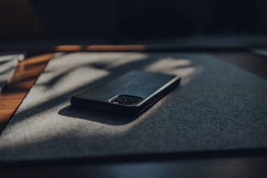 Londra, İngiltere - 5 Mayıs 2020: AppleiPhone 11 Pro Max deri çantalı, seçici odaklı. Apple yakın tarihte, kilitleme sırasında Harita kullanıcılarının seyahat davranışlarındaki değişiklikleri ortaya çıkaran bir araç başlattı.