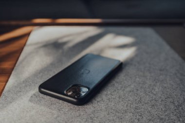 Londra, İngiltere - 5 Mayıs 2020: AppleiPhone 11 Pro Max deri çantalı, seçici odaklı. Apple yakın tarihte, kilitleme sırasında Harita kullanıcılarının seyahat davranışlarındaki değişiklikleri ortaya çıkaran bir araç başlattı.