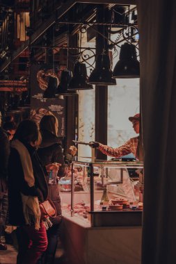 Madrid, İspanya - 26 Ocak 2020: Mercado de San Miguel 'deki bir tezgahtan yemek deneyen kadın (