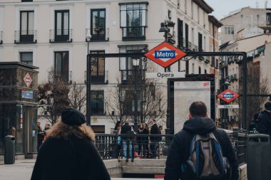 Madrid, İspanya - 26 Ocak 2020: İspanya 'nın başkenti Madrid' deki Opera Metro İstasyonu 'nun girişinde imzala, Avrupa sanatının zengin depoları, yanından geçen insanlar, seçici odak noktası.