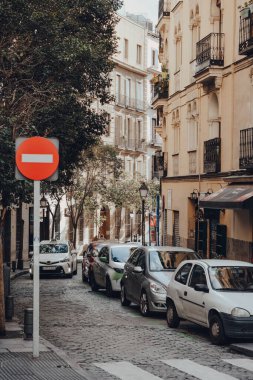 Madrid, İspanya - 26 Ocak 2020: Güneşli bir kış gününde İspanya 'nın başkenti Madrid' in tek yönlü dar bir caddesinde dur tabelası