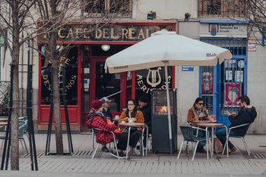 Madrid, İspanya - 26 Ocak 2020: İspanya 'nın başkenti Madrid' deki Cafe del Real Cafe 'nin açık masalarında oturan insanlar, Avrupa sanatının zengin depoları ve seçici odaklarıyla tanınıyorlar..