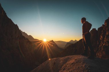 Avusturya 'nın Styria kentindeki Kireçtaşı Alpleri' nin manzaralı dağ sırasındaki Gsengscharte 'de gün batımını izleyen yürüyüşçü.