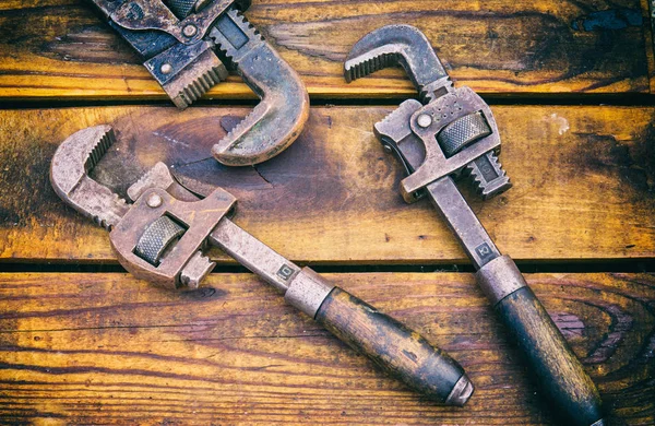 Antike Vintage-Schraubenschlüssel vor Holz-Hintergrund Stockfoto
