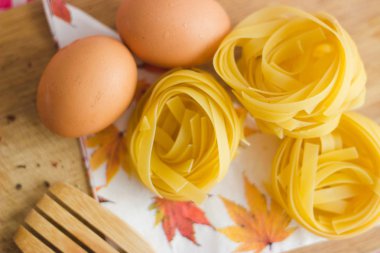 Natürmort hammaddelerini ev yapımı makarna ve yumurta bir cutboard tablo ahşap bir çatal ile