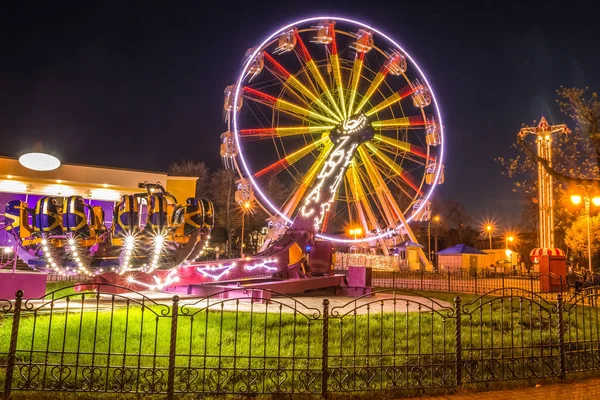 Paseos de diversión en un parque de atracciones por la noche. Gomel, Belarús —  Fotos de Stock