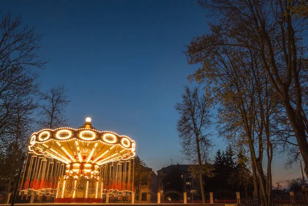 Carrusel infantil iluminado en un parque de atracciones — Foto de Stock