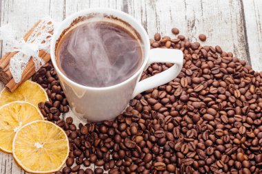 Kahve çekirdekleri ve içecek masada fincanla