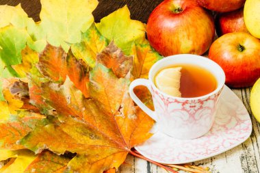 Bir porselen tabak olgun elma ve akçaağaç l arasında limonlu çay