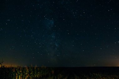Gece gökyüzünde yıldız bir alanın üzerinde