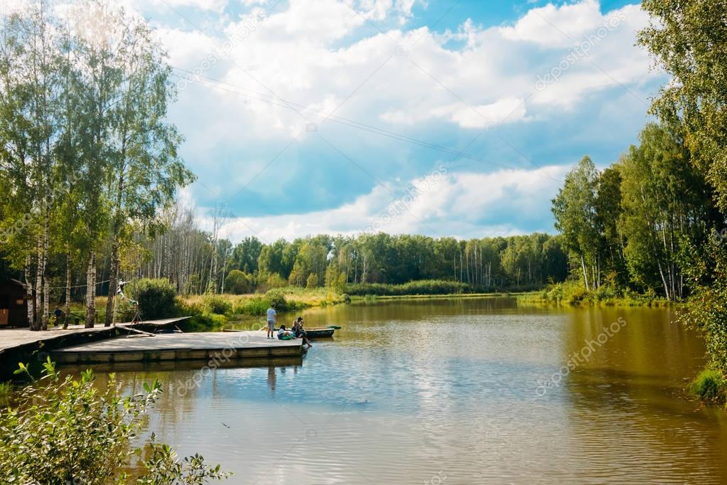 Forest Lake on a summer day with tourists. Village Petrovo, Russ