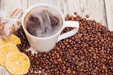 Beyaz fincan kahve kahve çekirdekleri arasında