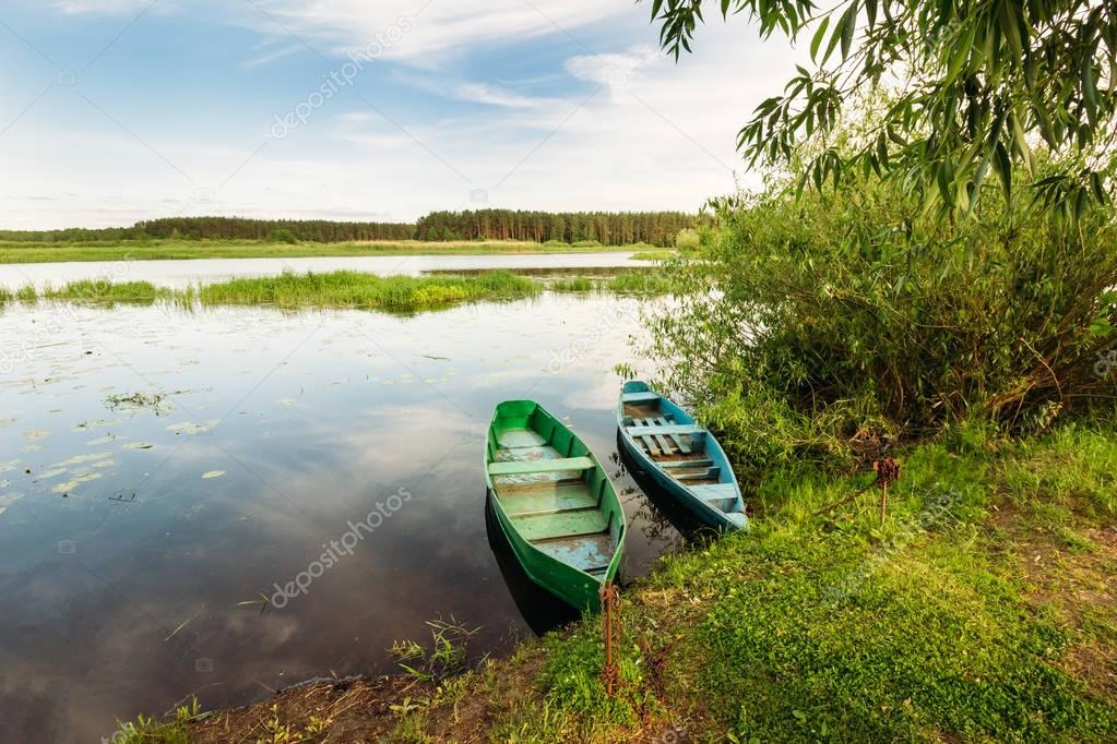 Old boats made of wood by the bush on the water