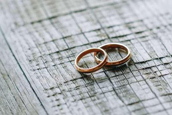 Dois anéis de casamento em uma textura de madeira — Fotografia de Stock