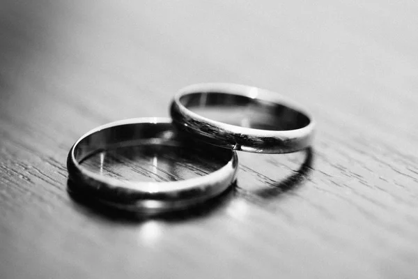 Rings of the newlyweds on the table black and white color — Stock Photo, Image