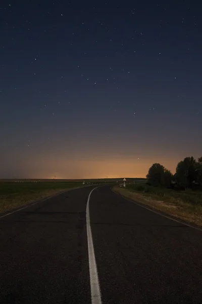 De weg onder de nachtelijke hemel met de sterren Stockafbeelding
