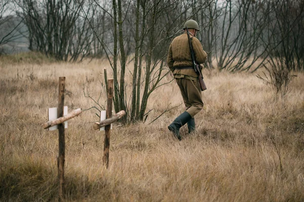 A soldier of the Red Army walks past graves — Stock Photo, Image