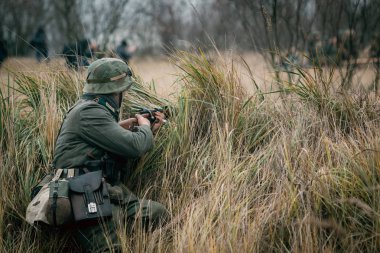 Alman asker Wehrmacht tüfekle saklanarak oturuyor