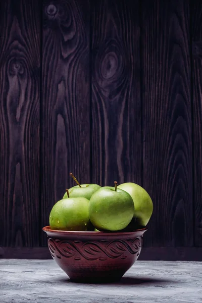 Beautiful apples in a bowl on a wooden background — Stock Photo, Image