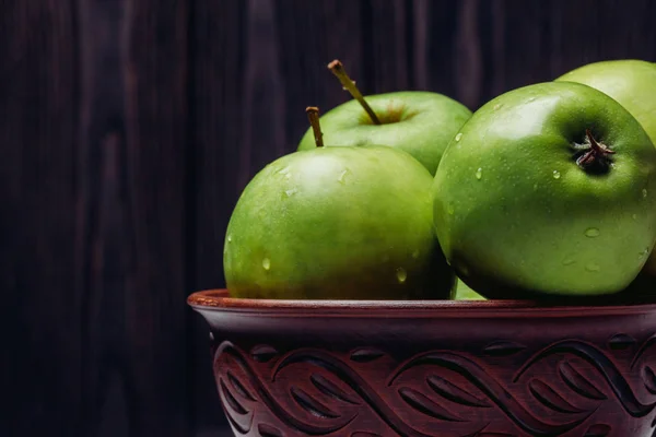 Green apples close-up in a clay bowl — Stock Photo, Image