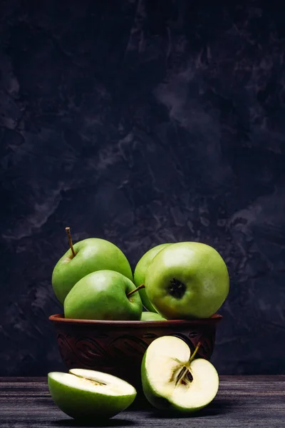 Apples are green in a bowl and a sliced apple — Stock Photo, Image