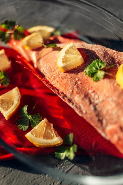 Baharatlı, limonlu, tuzlu ve maydanozlu bir kabın içinde kırmızı levrek. Yakın çekim, üst görünüm