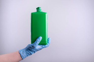 Bir doktorun, bir doktorun elinde antiseptik. Eldivenli yeşil bir şişede septocide. Beyaz arka plan. Eczacının elinde antiseptik var..