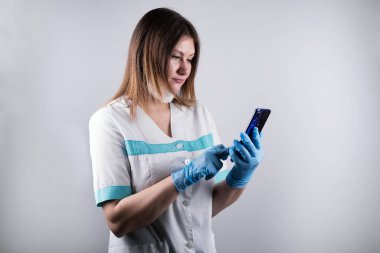 Doktor, hemşire telefonda konuşuyor. Genç doktor, sağlık görevlisi çağrıyı kabul ediyor. Özel korumalı eldivenli genç bayan..