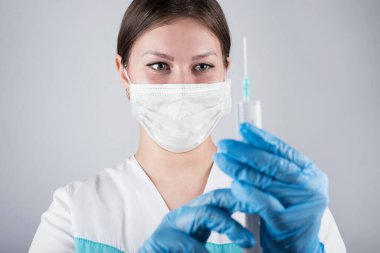 Şırınga, elinde tıbbi enjeksiyon, avuç içi ya da parmak. İğneli tıbbi plastik aşı ekipmanı. Hemşire ya da doktor. Sıvı uyuşturucu ya da uyuşturucu. Hastanede sağlık hizmeti.
