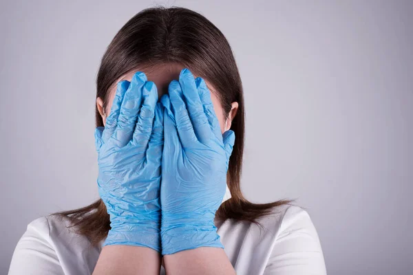 COVID-19 Coronavirüs salgını. Mutlu Avrupalı doktor, umut dolu, hastanede cerrahi maske ve mavi koruyucu eldiven takıyor. Krizi çözmek için geleceğe güven aşılayın..