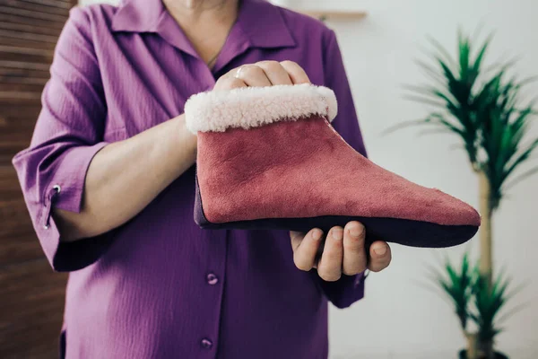 El yapımı sıcak yün terlikler. Koyun derisi terliklerin farklı renkleri. Doğal yün terlikler ve dayanıklı, kaymaz taban.