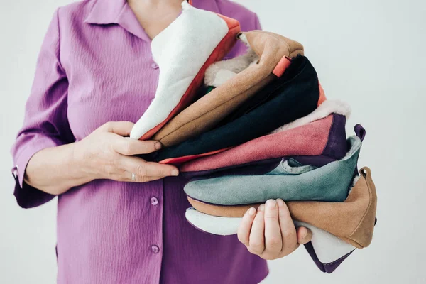 El yapımı sıcak yün terlikler. Koyun derisi terliklerin farklı renkleri. Doğal yün terlikler ve dayanıklı, kaymaz taban.