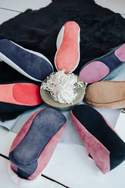 El yapımı sıcak yün terlikler. Koyun derisi terliklerin farklı renkleri. Doğal yün terlikler ve dayanıklı, kaymaz taban.