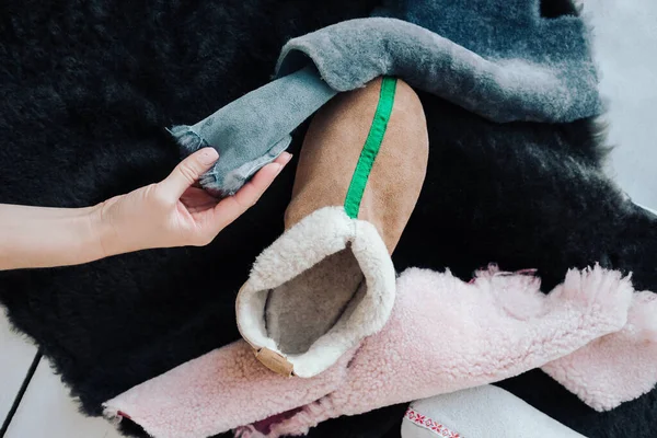 El yapımı sıcak yün terlikler. Koyun derisi terliklerin farklı renkleri. Doğal yün terlikler ve dayanıklı, kaymaz taban.