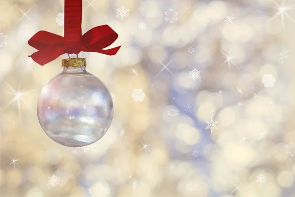 Pelota de Navidad vacía transparente. Bola de Navidad, cuelga de una cinta roja en el fondo de luces de plata desenfocadas . —  Fotos de Stock