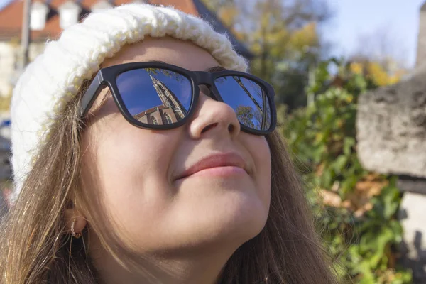 Lugares de interés de la ciudad vieja se reflejan en las gafas en la cara de una joven sonriente, primer plano, Munich, Alemania — Foto de Stock