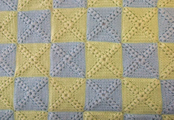 Handgestrickte bunte Decken blau und grün, sanfte Farben. farbenfrohe originelle handgestrickte Handarbeit. Häkelmaschen. rustikaler Hintergrund — Stockfoto