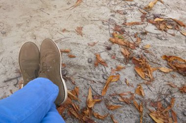 Rahatça dinleniyor kahverengi Ayakkabı ve kot giyen kadın ayakları. Sonbahar tatil kavramı.