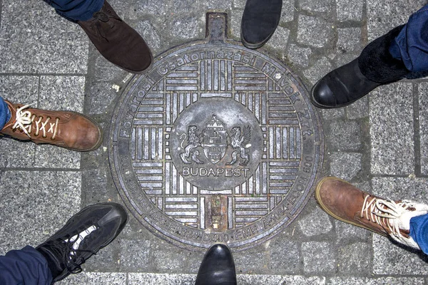 Угорщина, Будапешт - Січень 2017 року: футів у взутті навколо каналізаційного люка покриття. — стокове фото