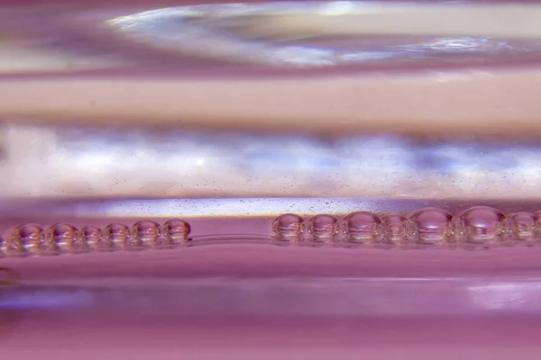 Beautiful drops of water  in a row on a gentle pink background. Abstract background with shallow depth of field.