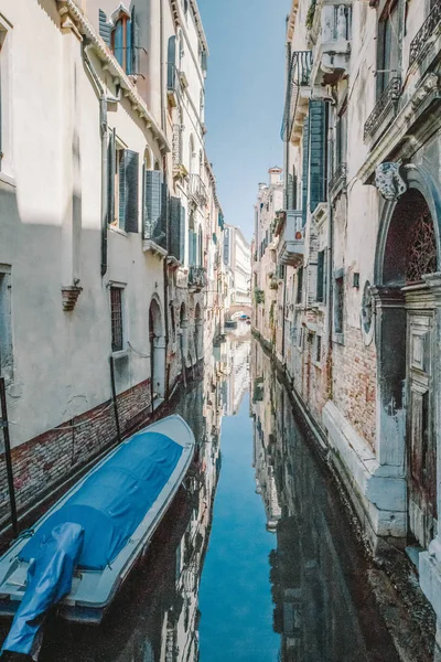 Bir ev bir tuğla duvar içinde dar bir canal, Venice, İtalya ile bağlı küçük bir mavi tekne