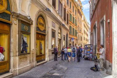 Rome, İtalya - 17 Haziran 2014: insanlar Hatıra Eşyası ile ticaret dar Arnavut kaldırımlı sokakları ile dükkanlar, yürüyorduk. Saksafon, Roma, İtalya, bir sokak müzisyen çalış.