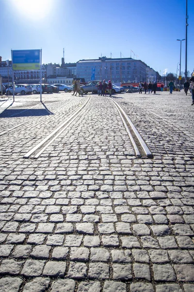 Cobbled road with beginning of rails - beginning / end of road, sunny afternoon in Helsinki, Finland.